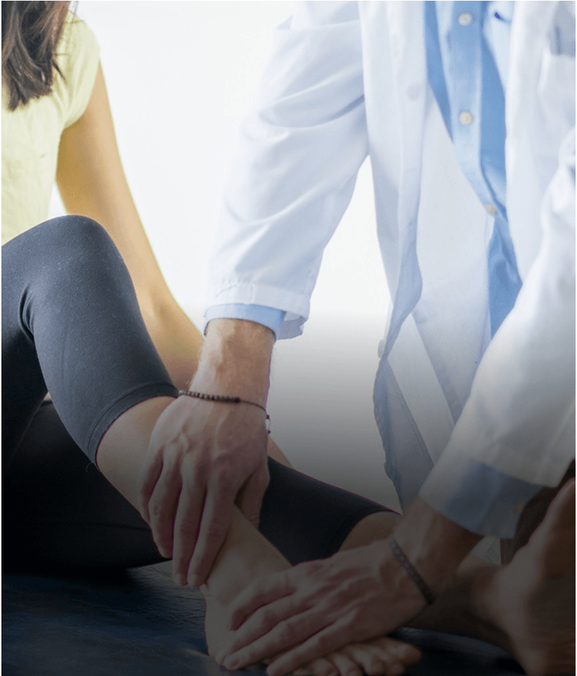 Doctor examining patient's ankle on table.